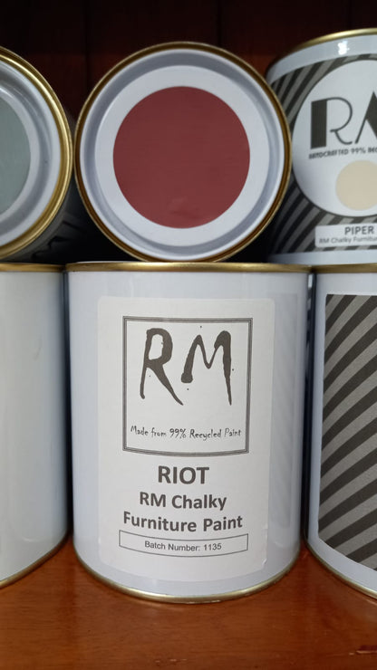 Cans of RM Chalky Furniture Paint with visible branding on a wooden surface.