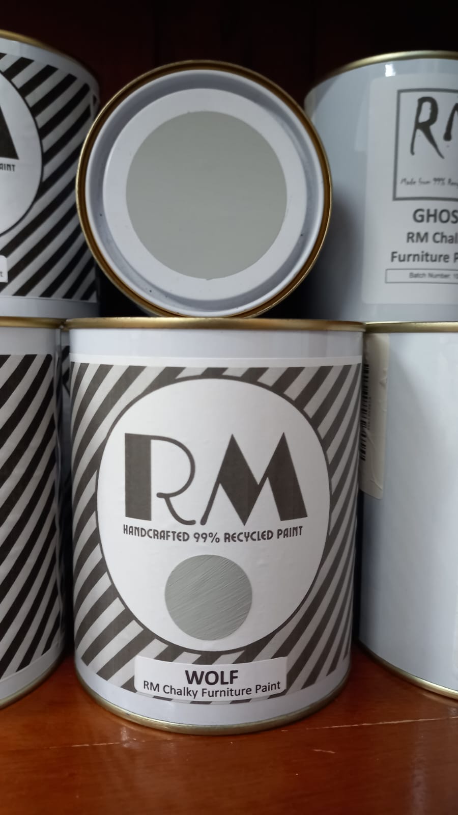 Cans of RM Chalky Furniture Paint with visible branding on a wooden surface.