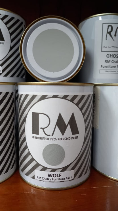 Cans of RM Chalky Furniture Paint with visible branding on a wooden surface.